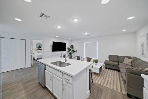 a kitchen and living room with a sink and a couch at Brand New House! 10 Minutes to the Beach! in West Palm Beach