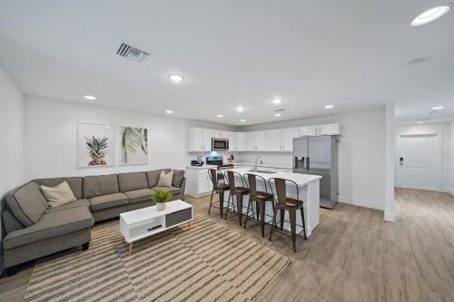 a living room with a couch and a kitchen at Brand New House! 10 Minutes to the Beach! in West Palm Beach