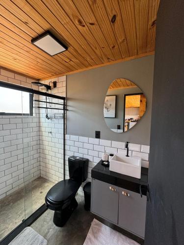 a bathroom with a sink and a toilet and a mirror at Refúgio Veadeiros Container in Sao Jorge