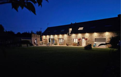 a brick building with a lawn in front of it at Cozy Home In Bourbriac in Bourbriac