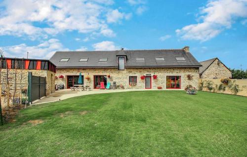 a stone house with a large lawn in front of it at Cozy Home In Bourbriac in Bourbriac
