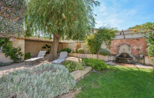 a garden with two chairs and a tree at Stunning Home In Noves With Wifi in Noves