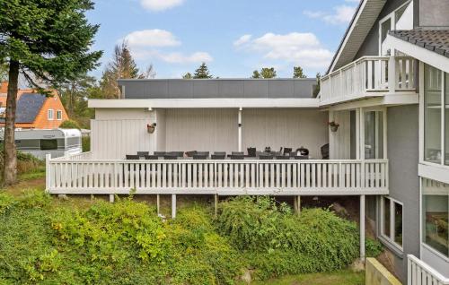 a house with a white deck with chairs on it at Stunning Home In Roslev With Sauna in Glyngøre