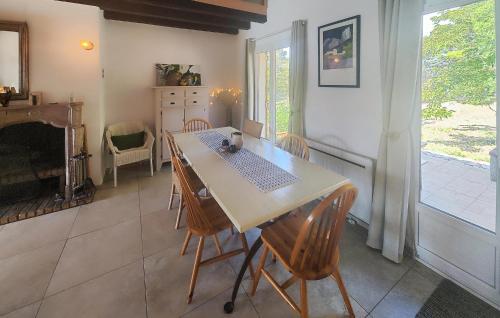 une salle à manger avec une table et des chaises et une cheminée dans l'établissement Amazing Home In Assignan, à Assignan
