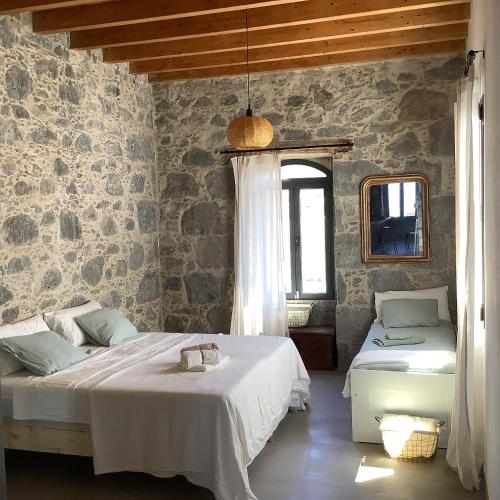 a bedroom with two beds in a room with stone walls at Villa Alpispa in Las Palmas de Gran Canaria