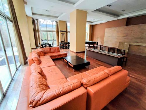 a living room with a leather couch and a table at Polanco Signaturepool, Paddle, Jacuzzi, 150mbs in Mexico City