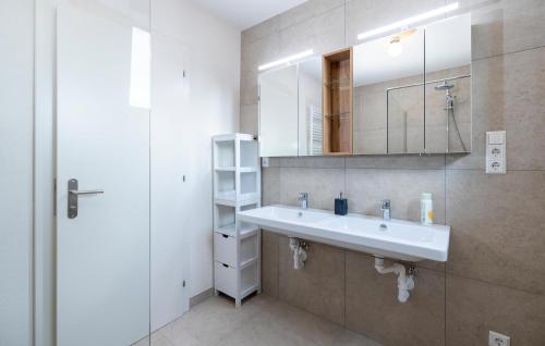 a bathroom with a sink and a mirror at 5 Bedroom Nice Home In Rechnitz in Rechnitz