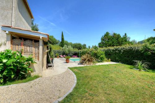 a garden with a path next to a building at Villa Néoulaise 12 couchages in Néoules
