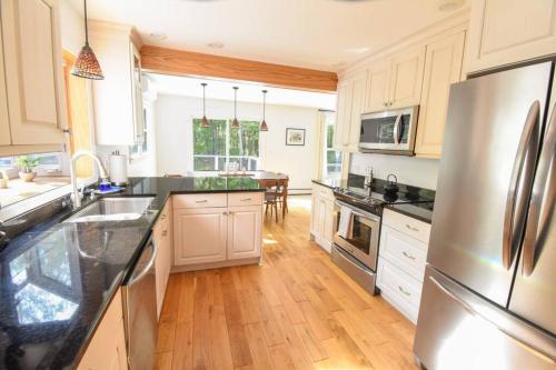 Red HookにあるHudson Valley Haven - NYの白いキャビネットとステンレス製の冷蔵庫を備えたキッチン