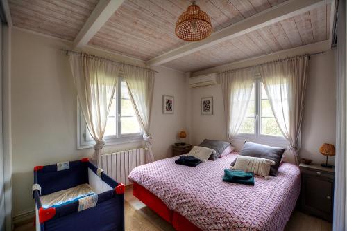 a bedroom with a bed and two windows at Villa Néoulaise 12 couchages in Néoules