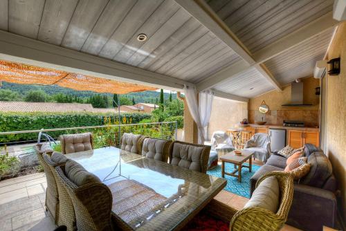 a living room with a glass table and chairs at Villa Néoulaise 12 couchages in Néoules