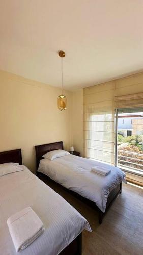 a bedroom with two beds and a window with a view at Villa - Royal Golf de Fez - Pool in Fez