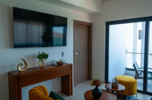 a living room with a fireplace and a tv at Sky & Sea View in Mazatlán