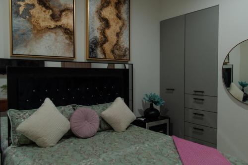 a bedroom with a bed with pillows and a mirror at Sky & Sea View in Mazatlán