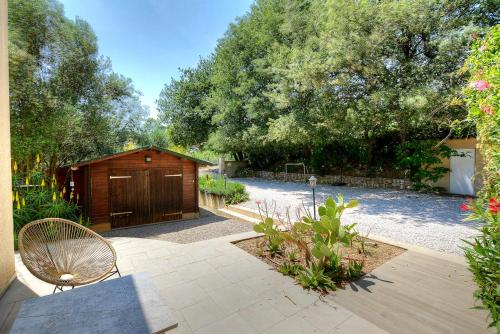 a garden with a wooden shed and a bench at Villa Néoulaise 12 couchages in Néoules