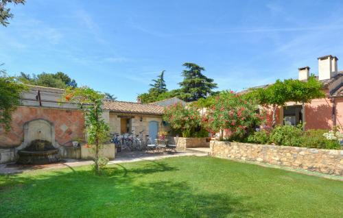 a house with a yard with a stone wall at Stunning Home In Noves With Wifi in Noves