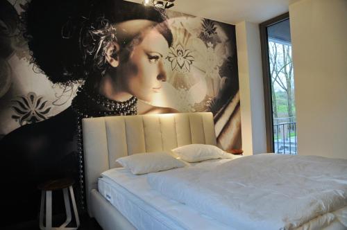 a bedroom with a large painting of a woman at Ard'cube in Noiseux