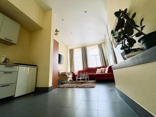 a kitchen and a living room with a red couch at Sija's house in Kaunas