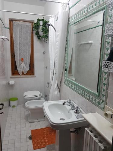 a bathroom with a sink and a toilet and a mirror at B&B il Terrazzo in Orvieto