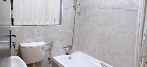 a bathroom with a toilet and a sink at Risima guest house in Kempton Park