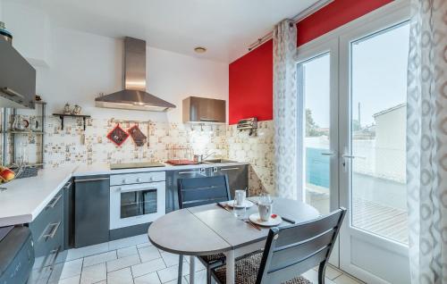 - une cuisine avec une petite table, une table et des chaises dans l'établissement Galets Blancs, à Royan