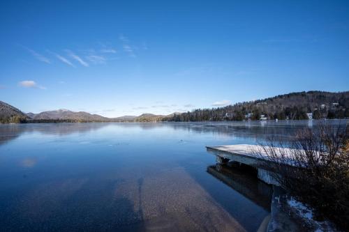 a lake with a dock in the middle of it at Suite with mountains view & Resort access in Lac-Superieur