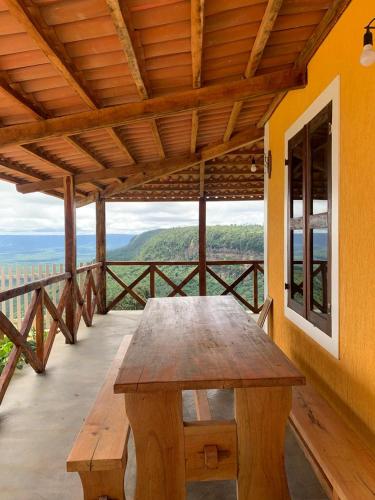 a wooden table on a porch with a view at Chalé do talhado in Ibiapina
