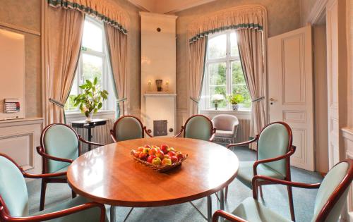 a room with a table and chairs and a bowl of fruit at Åkeshofs Slott in Stockholm