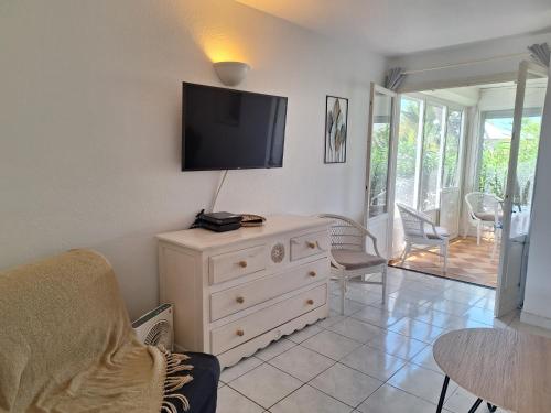 a living room with a dresser with a tv on the wall at Dolce Vita Anse Margot in Marigot
