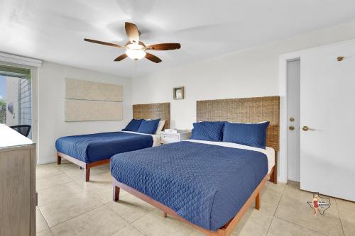 a bedroom with two beds and a ceiling fan at Bahia Mar Solare Beachfront Resort Condos with Two Pools in South Padre Island
