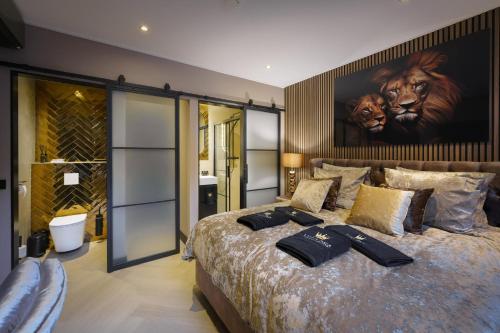 a bedroom with a large bed with a painting on the wall at Villa B&B Bovenkarspel in Bovenkarspel