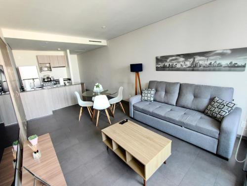 a living room with a couch and a table at Luxurious High-Rise HS WiFi, amazing city views in Mexico City