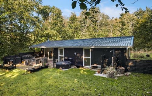 una casa negra con una parrilla en un patio en 2 Bedroom Lovely Home In Hadsund, en Hadsund