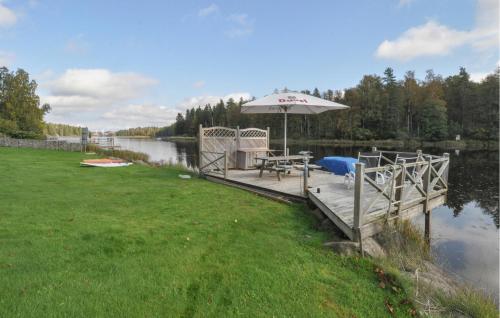 a dock with a table and an umbrella on a lake at Stunning Home In Degerfors With Sauna in Degerfors