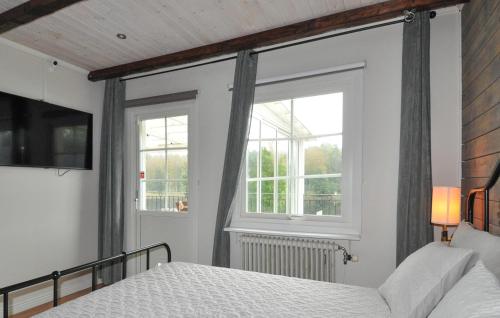 a bedroom with a bed and two windows at Stunning Home In Degerfors With Sauna in Degerfors