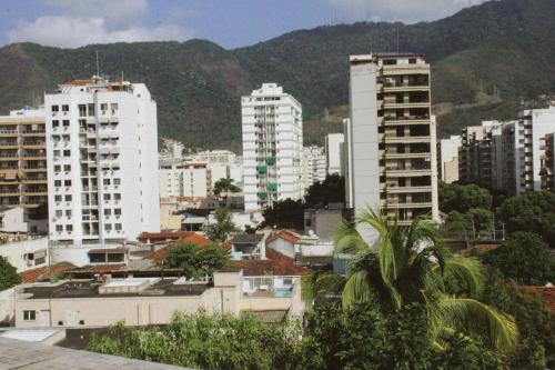 eine Stadt mit hohen weißen Gebäuden und Bergen in der Unterkunft Casa da Carioca com vista para Floresta Tijuca in Rio de Janeiro