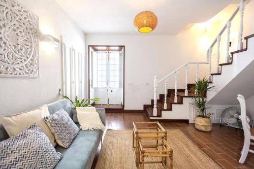 a living room with a blue couch and stairs at Casa Maria Amalia in Cascais