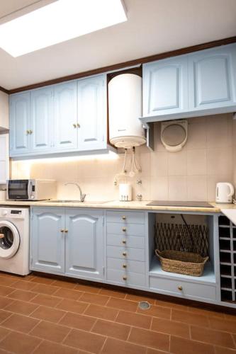 a kitchen with white cabinets and a washing machine at Casa Maria Amalia in Cascais