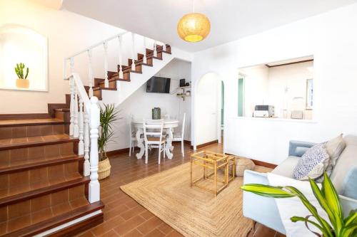 a living room with a staircase and a dining room at Casa Maria Amalia in Cascais