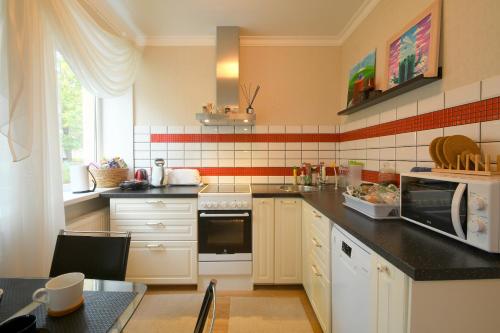 kuchnia z białymi szafkami i czarnym blatem w obiekcie Sunset lovers apartment w mieście Lipawa