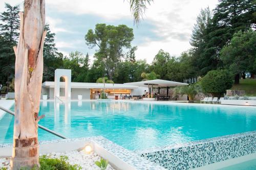 a large swimming pool with a building in the background at Parque Hotel in Villa Carlos Paz