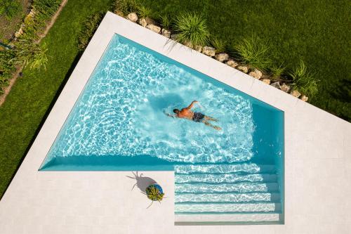 an overhead view of a man swimming in a swimming pool at Villa Aura Heated Pool&Jacuzzi near Albena in Rogachevo