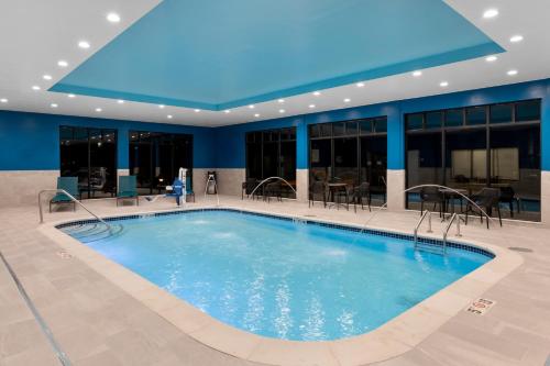 a large swimming pool in a building with a blue ceiling at Hampton Inn Saline in Saline