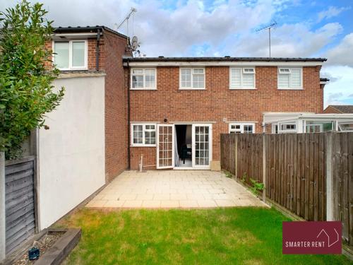 a brick house with a fence and a yard at Farnham - 2 Bedroom House - With Garden and Parking in Hale