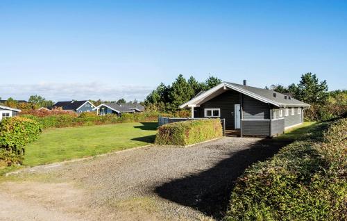 a small house on a gravel road next to a field at Amazing Home In Tarm With Sauna in Tarm