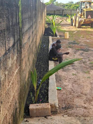 a man sitting on a bench next to a wall at Safim Suites in Plaque