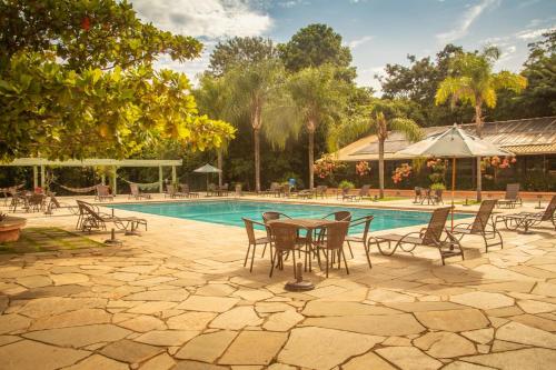 a patio with a table and chairs next to a pool at Hotel Fazenda Brisa Itu in Itu