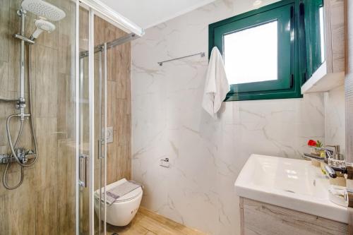 a bathroom with a shower and a toilet and a sink at Gkountis Deluxe King Suite 2 in Tsoukaladhes