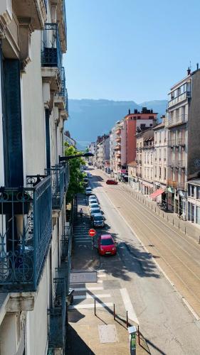 une rue de la ville avec une voiture rouge garée dans la rue dans l'établissement Le Berriat, proche Gare-CCI-GEM, à Grenoble
