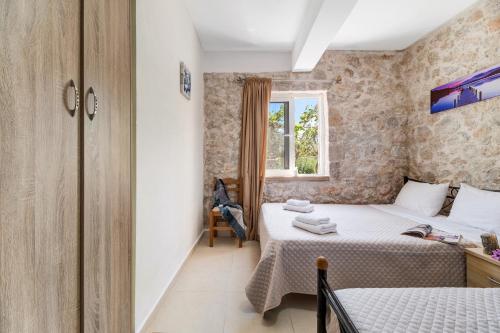 a small bedroom with two beds and a window at Gkountis stone apartment 5 in Tsoukaladhes